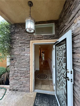 a view of a hallway with wooden floor and a chandelier