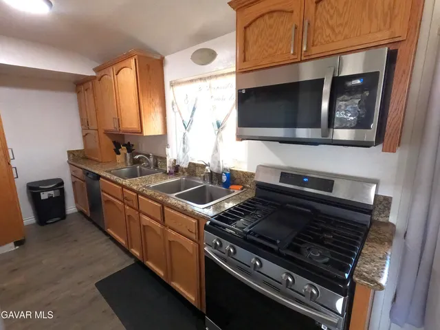 a kitchen with stainless steel appliances a stove and a microwave