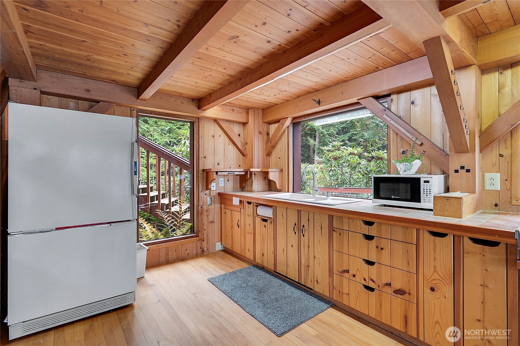 861 Griffith Point Road Nordland, WA 98358 - Photo 11 of 38 a kitchen with stainless steel appliances granite countertop a refrigerator a sink dishwasher a stove and white countertops with wooden floor