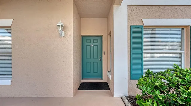 a living room with furniture potted plant and kitchen view