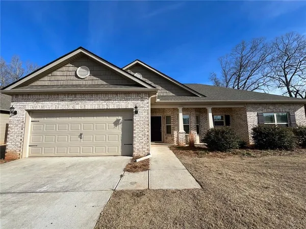 a front view of a house with a yard and outdoor seating