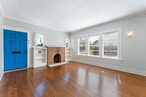 a view of a livingroom with a fireplace wooden floor and window