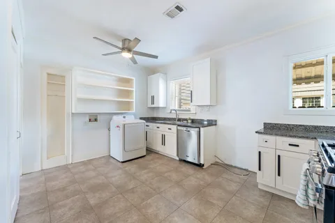 a kitchen with a stove top oven cabinets and a window