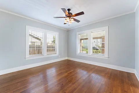 a view of wooden floor and a chandelier fan in a room