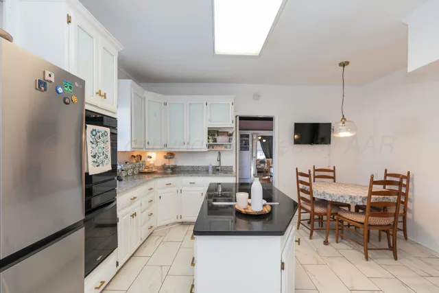 a kitchen with stainless steel appliances kitchen island granite countertop a refrigerator and microwave