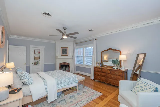 a bedroom with a bed wooden floor and a lamp on table