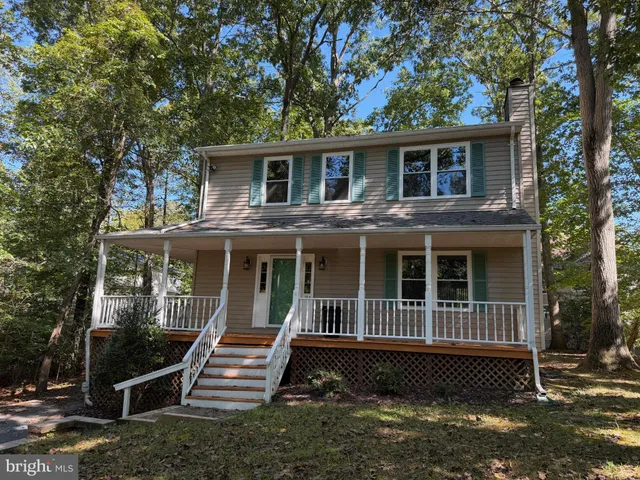 a view of house with a yard and wooden fence