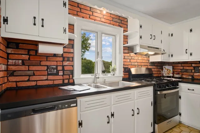 a kitchen with stainless steel appliances granite countertop a sink and a stove