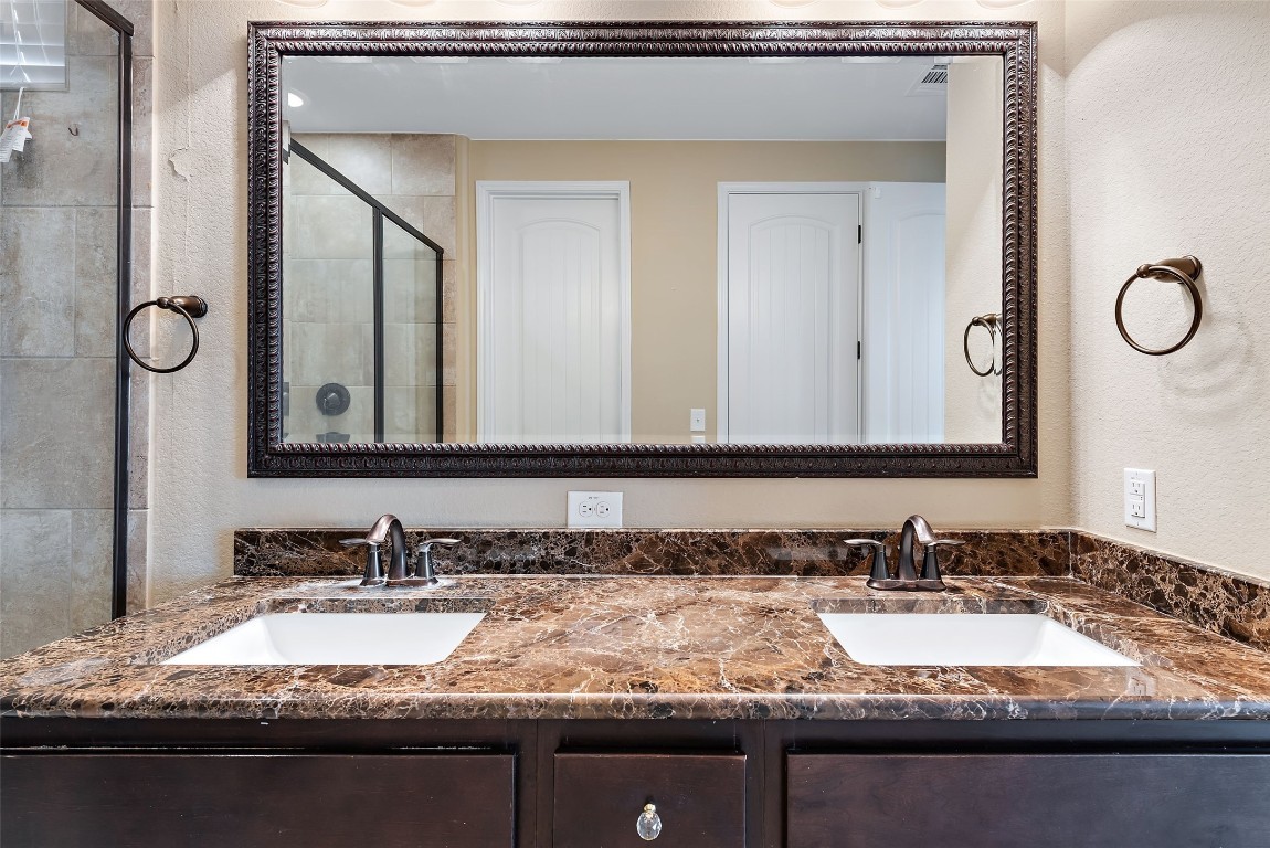 2000 Manada Trail Leander, TX 78641 - Photo 21 of 36 A generous double vanity with a marble countertop provides ample space in this well-appointed bathroom.
