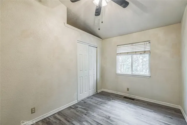 an empty room with a window and wooden floor