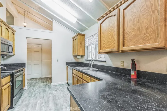 a kitchen with stainless steel appliances granite countertop a refrigerator a sink and a stove