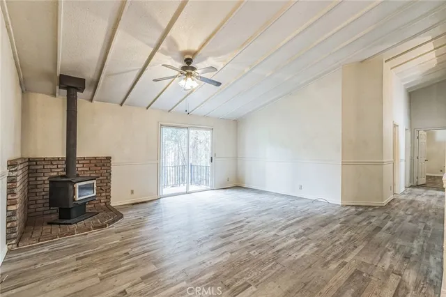 a view of a room with wooden floor a ceiling fan and windows