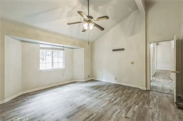 a view of room with hardwood floor and a ceiling fan
