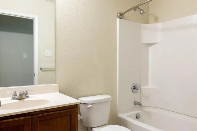 an empty room with wooden floor fireplace and windows