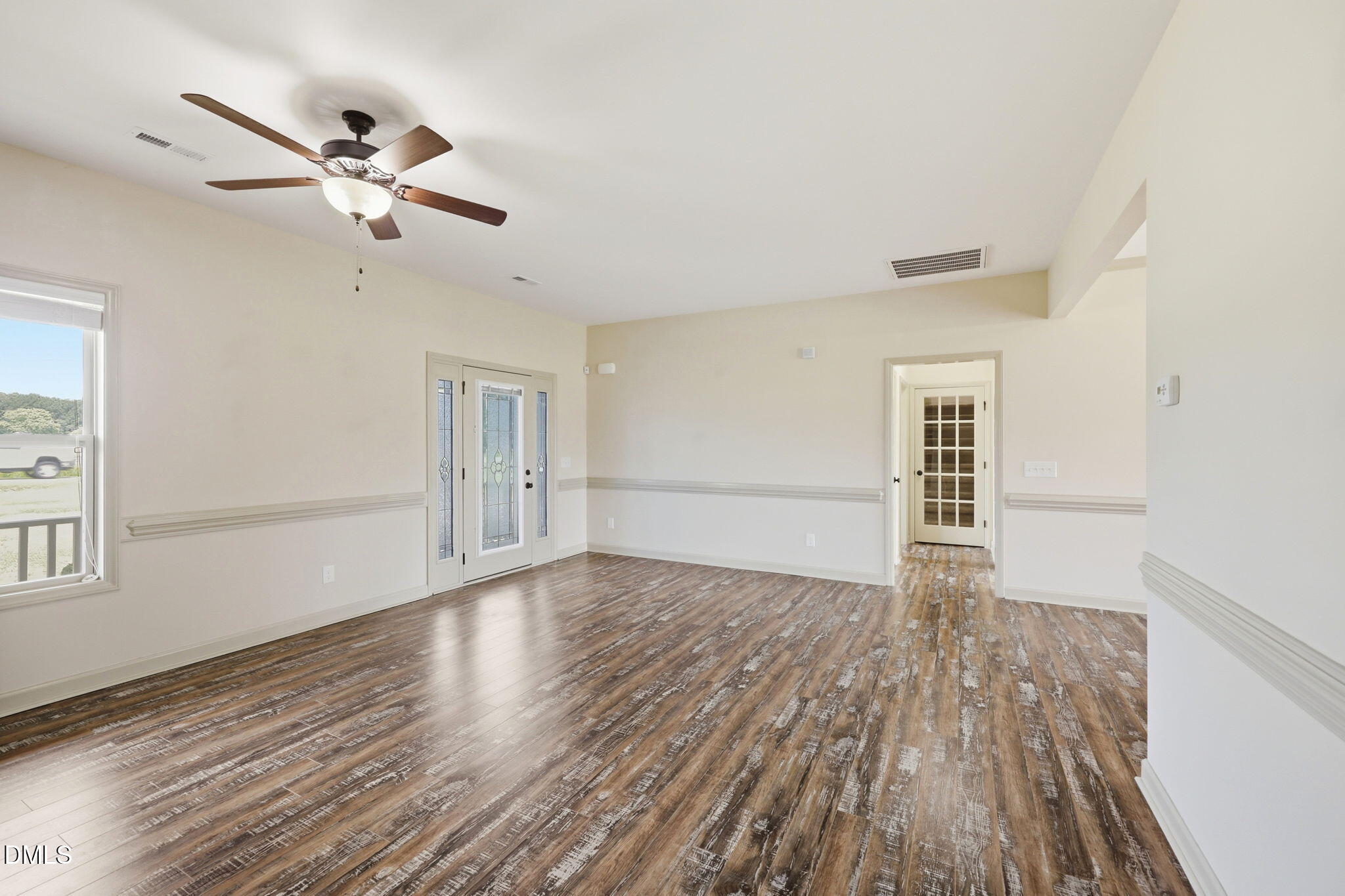 3587 Hannah Creek Road Benson, NC 27504 - Photo 7 of 43 a view of an empty room with wooden floor and a window