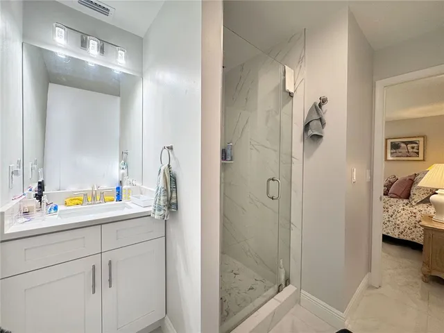 a en suite bathroom with a shower sink and mirror
