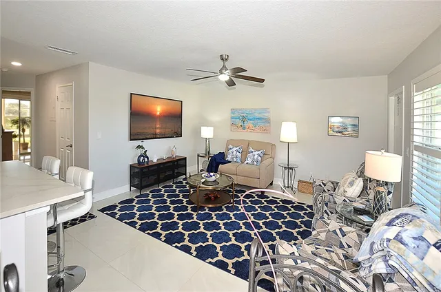 a living room with furniture a flat screen tv and a table