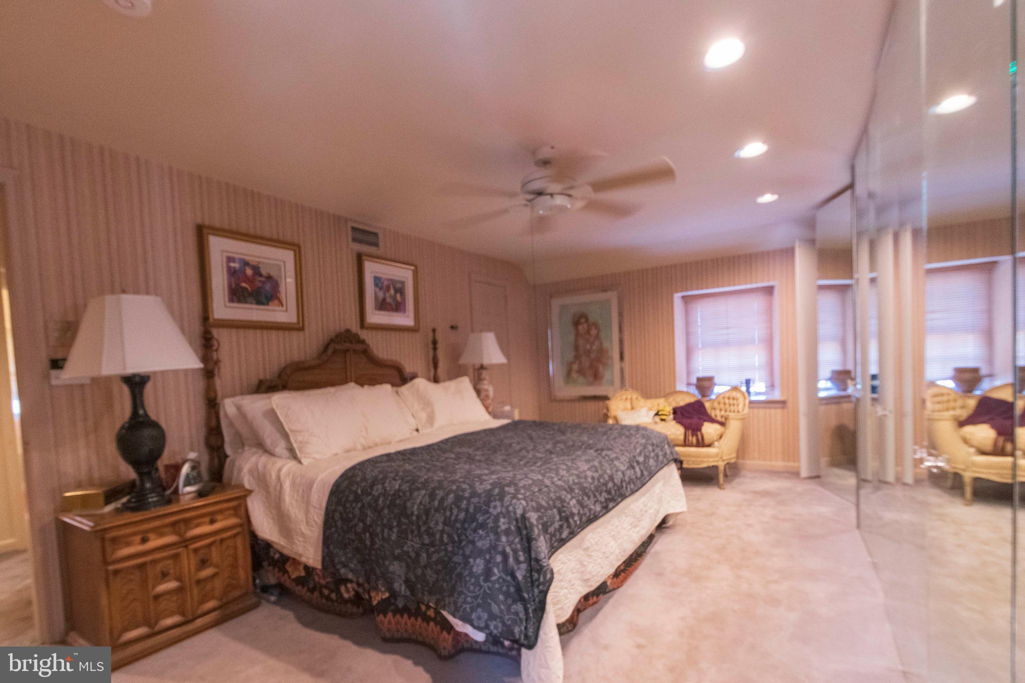 540 Putnam Road Merion Station, PA 19066 - Photo 24 of 32 a spacious bedroom with a large bed and a chandelier
