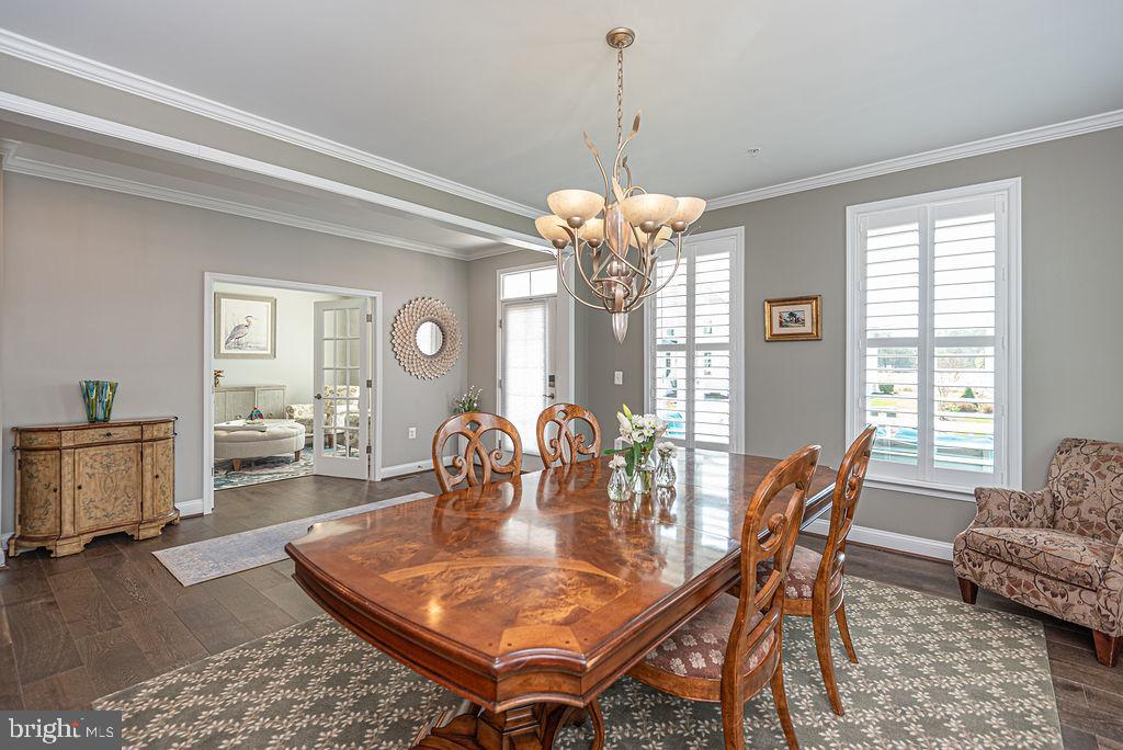 10214 Battle Colors Lane Berlin, MD 21811 - Photo 14 of 77 a dining room with furniture a chandelier and wooden floor