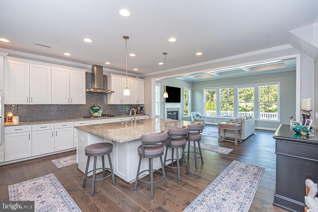 10214 Battle Colors Lane Berlin, MD 21811 - Photo 15 of 77 a large dining hall with stainless steel appliances granite countertop a stove a sink a dining table and chairs with wooden floor