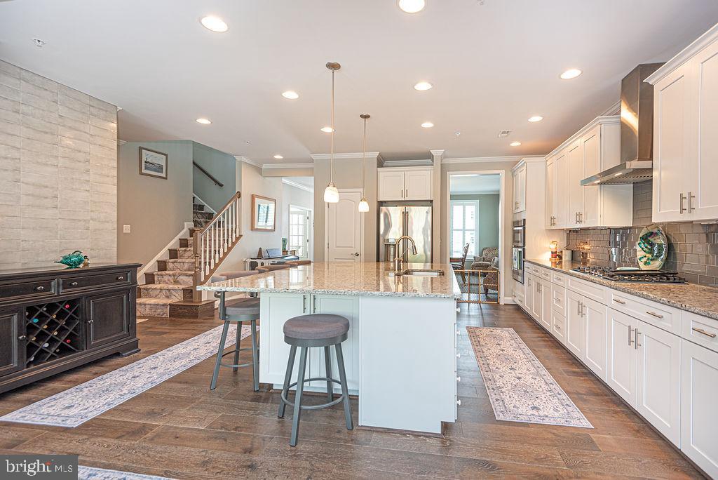 10214 Battle Colors Lane Berlin, MD 21811 - Photo 21 of 77 a large white kitchen with lots of counter space and a wooden floor