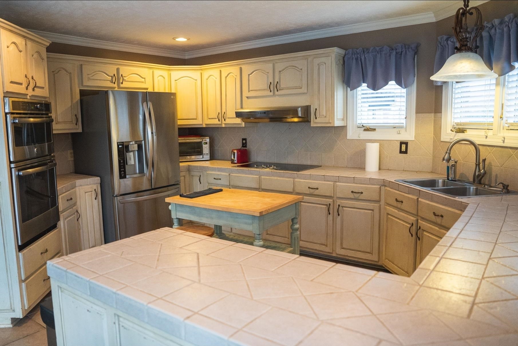 103 April Cove Ripley, TN 38063 - Photo 7 of 22 a kitchen with stainless steel appliances kitchen island granite countertop a sink refrigerator stove and microwave