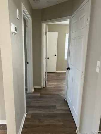 a view of a hallway with wooden floor and closet area