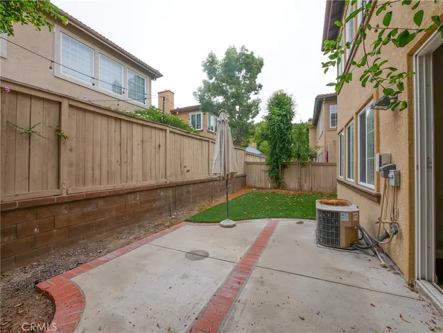 a view of a backyard with potted plants and a large tree