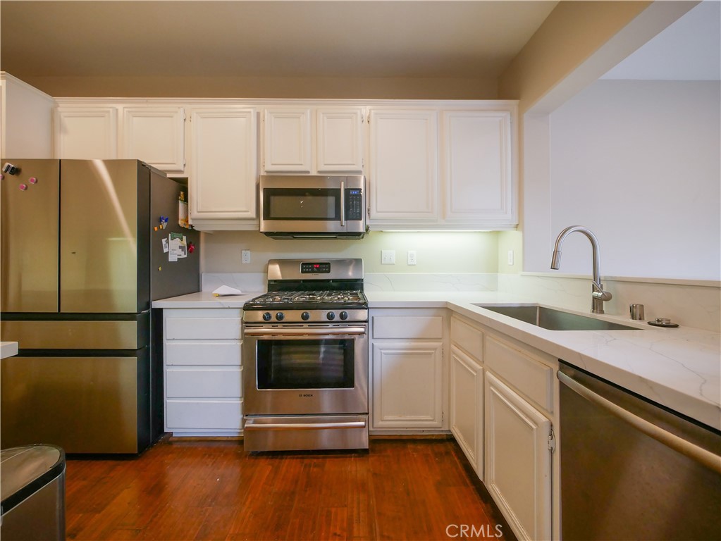 67 Ardmore Irvine, CA 92602 - Photo 5 of 16 a kitchen with a sink a microwave a refrigerator and cabinets