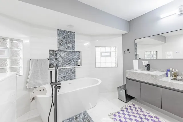a bathroom with a tub sink shower and mirror