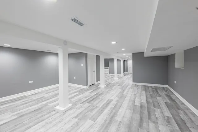 a view of empty room with wooden floor