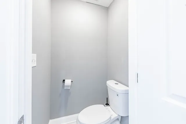 a white toilet sitting next to a white walls