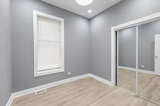 an empty room with windows and closet