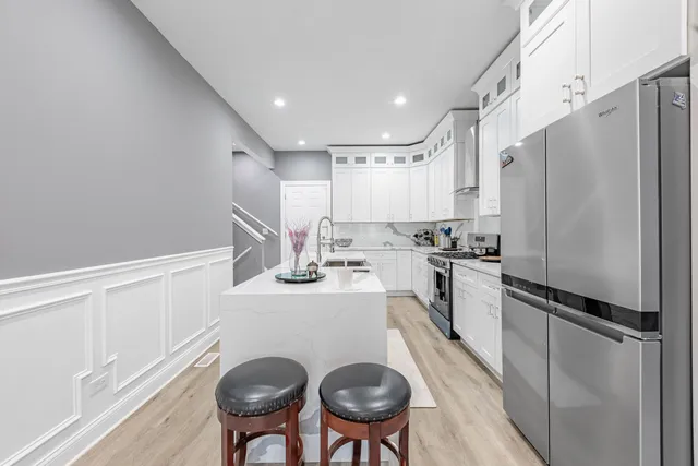 a kitchen with refrigerator cabinets and chairs