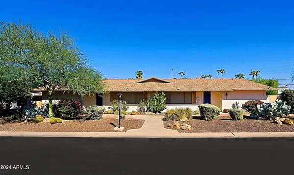 a front view of a house with a garden