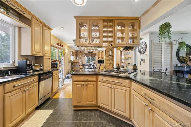 a kitchen with stainless steel appliances granite countertop a refrigerator a stove and a sink with cabinets