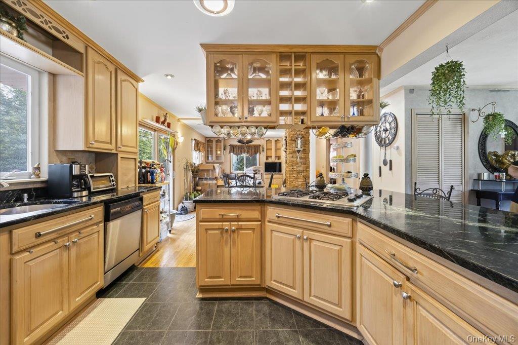 11 Merriewold Lane North Monroe, NY 10950 - Photo 12 of 48 Kitchen with glass insert cabinets, dark stone counters, stainless steel appliances, dark tile patterned flooring, and ornamental molding