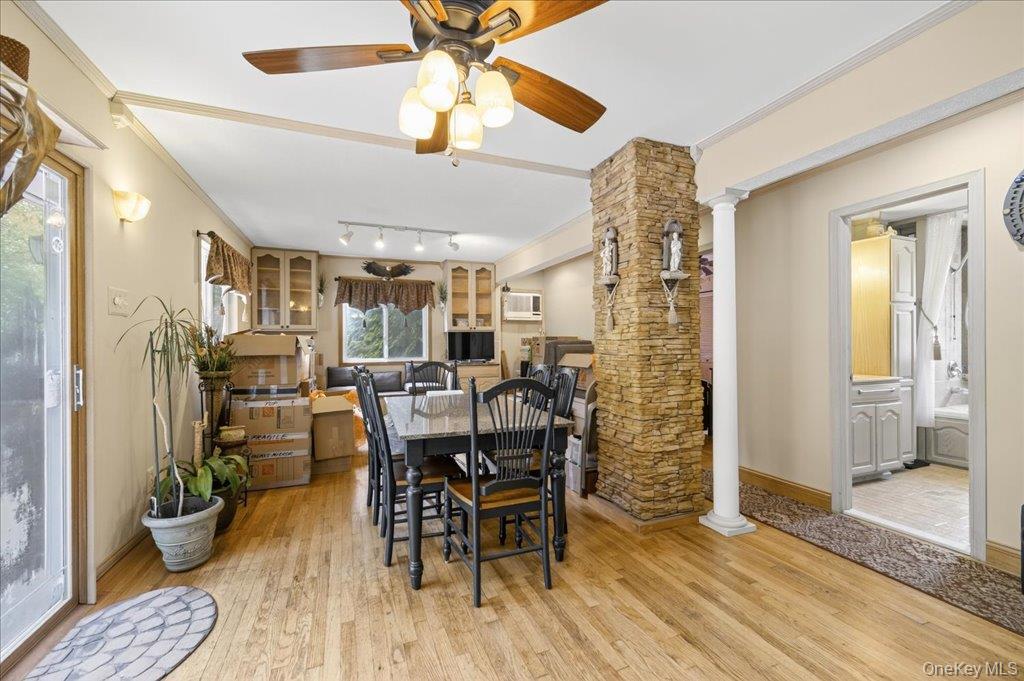 11 Merriewold Lane North Monroe, NY 10950 - Photo 15 of 48 Dining area featuring decorative columns, crown molding, light wood-style flooring, and a ceiling fan