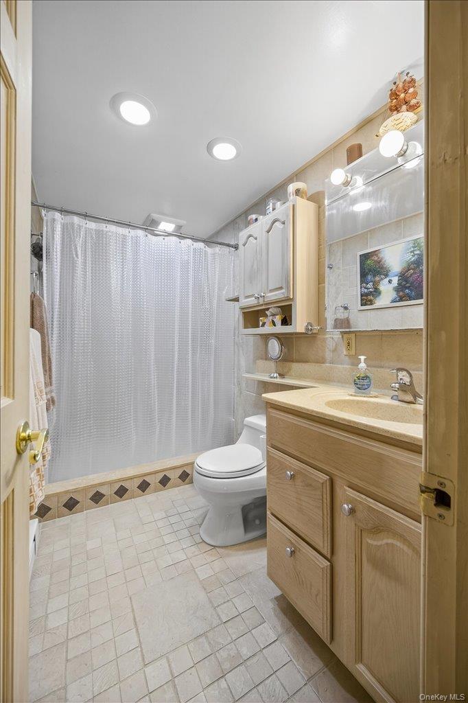 11 Merriewold Lane North Monroe, NY 10950 - Photo 30 of 48 Full bathroom featuring vanity, a shower stall, light tile patterned flooring, recessed lighting, and tile walls
