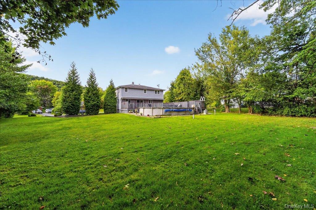 11 Merriewold Lane North Monroe, NY 10950 - Photo 41 of 48 View of green lawn featuring a wooden deck, an outdoor pool, and view of scattered trees