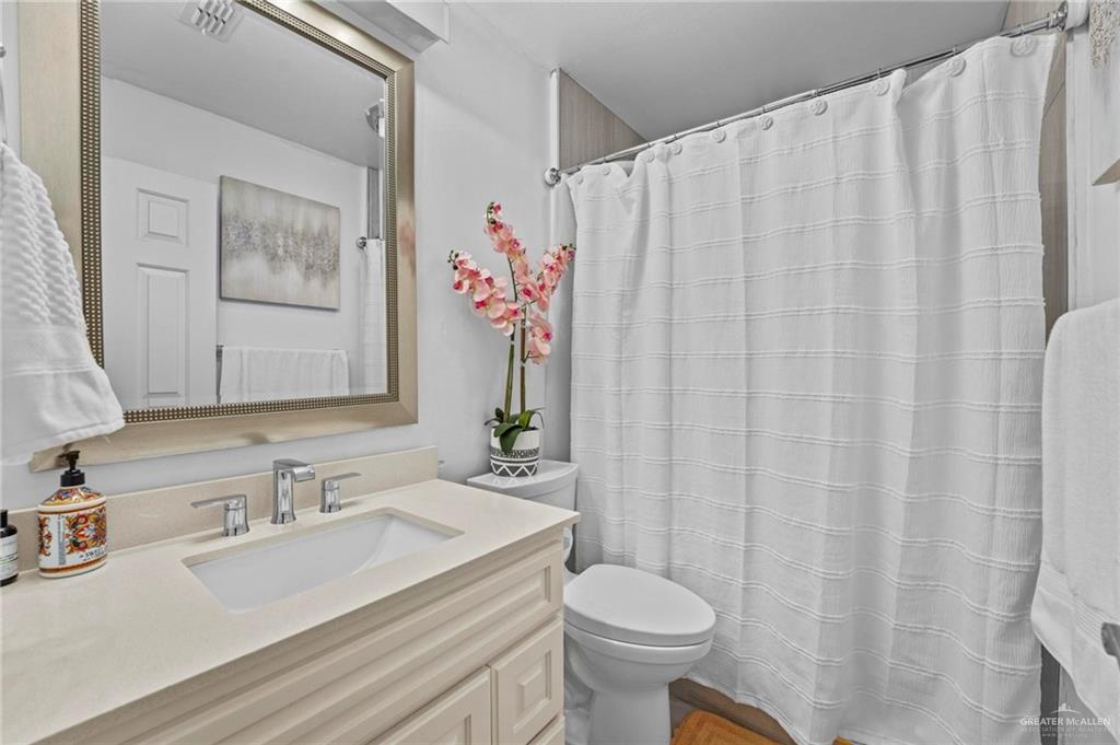7411 East Texas Road Edinburg, TX 78542 - Photo 14 of 20 a bathroom with a granite countertop sink and a mirror