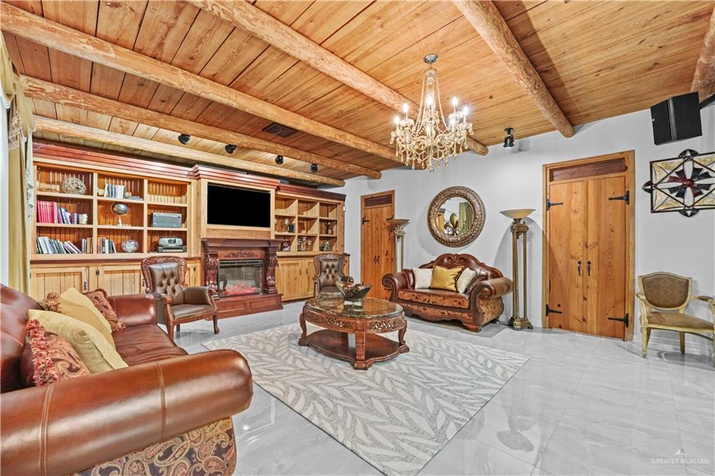 7411 East Texas Road Edinburg, TX 78542 - Photo 2 of 20 a living room with furniture a fireplace and a chandelier