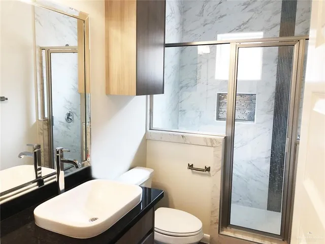 a bathroom with a toilet a sink and a large mirror