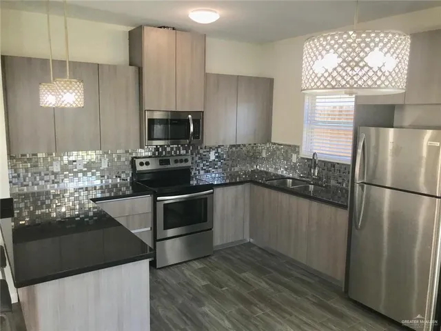 a kitchen with granite countertop a refrigerator and a stove