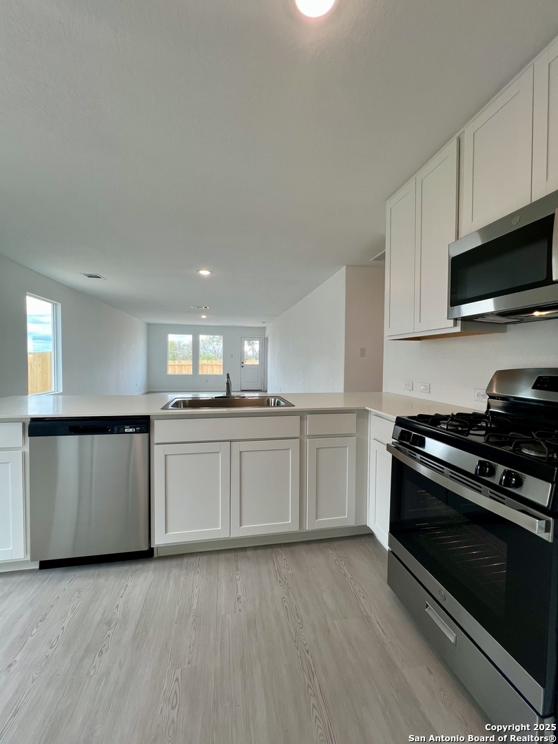9178 Colonel Trail Seguin, TX 78155 - Photo 14 of 59 a kitchen with granite countertop a sink and a stove top oven