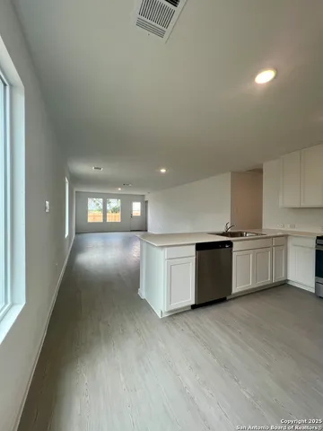 a kitchen with white cabinets and stainless steel appliances