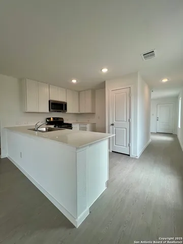 a kitchen with cabinets stainless steel appliances and a sink
