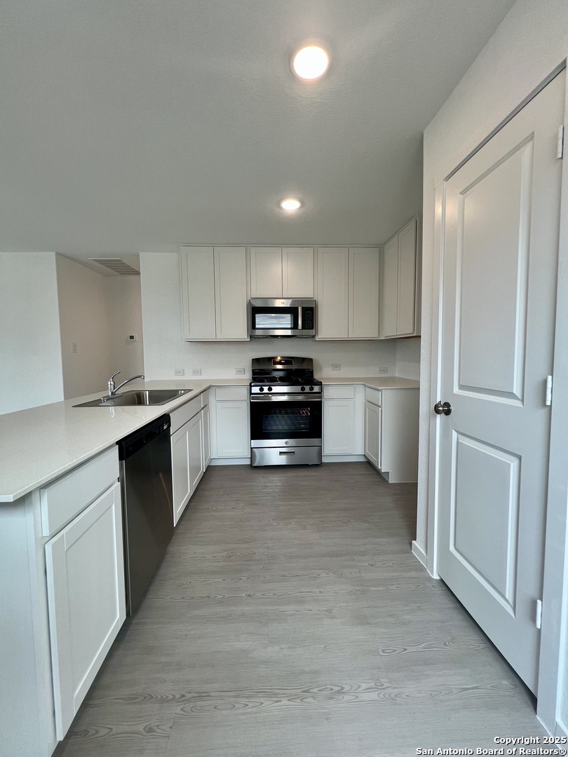 9178 Colonel Trail Seguin, TX 78155 - Photo 10 of 59 a kitchen with granite countertop a refrigerator and white cabinets