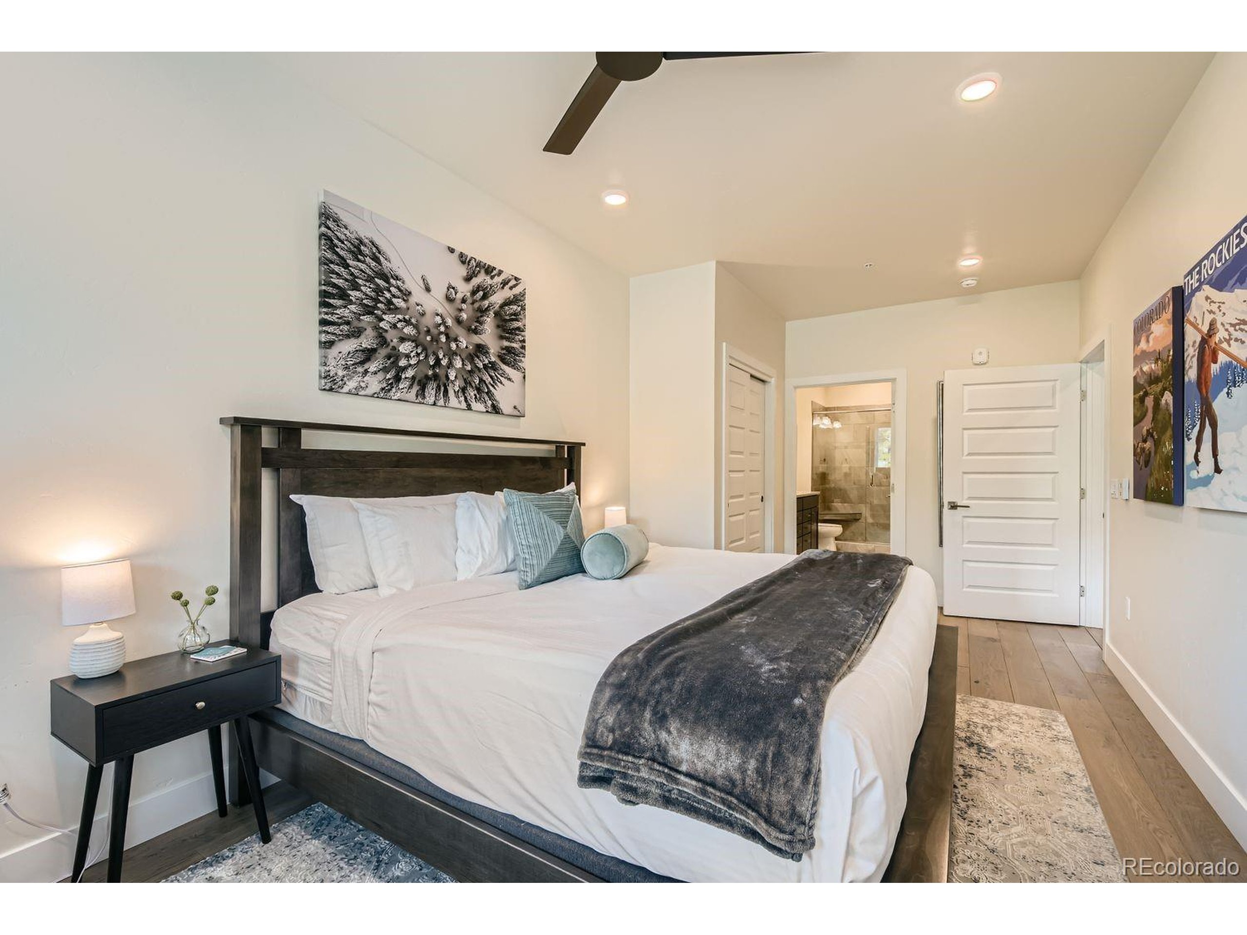 0075 Clearwater Way, Unit 302 Dillon, CO 80435 - Photo 13 of 33 a bedroom with a bed a mirror and paintings on the wall