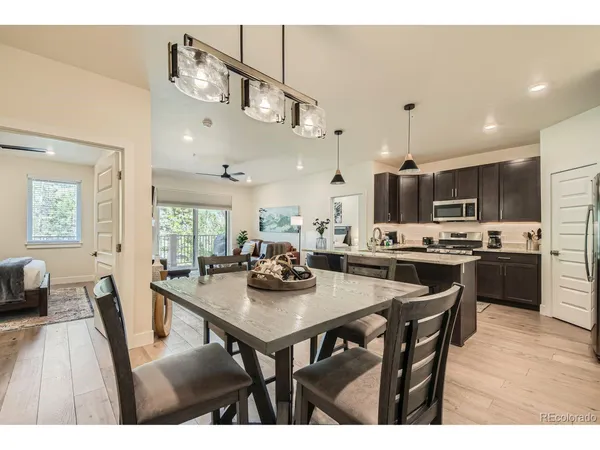 a kitchen with a dining table chairs and view living room